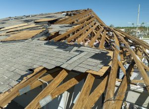 Damaged house roof with missing shingles after hurricane Ian in Florida. Consequences of natural disaster.